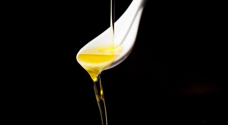 Olive oil being poured onto a spoon and then pouring off again