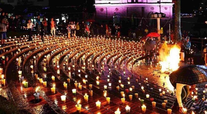 The steps of a public place covered in many little candles at night