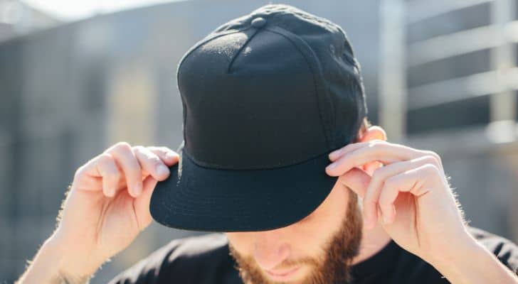 A man with a beard wearing a black baseball cap