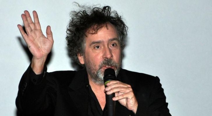 Tim Burton holding a microphone during an interview