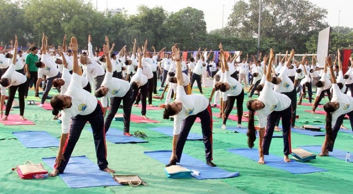 A large crowd of people practicing yoga in India