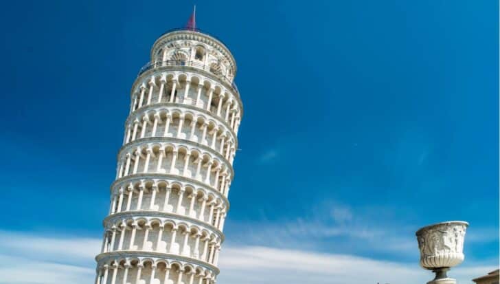 The Leaning Tower of Pisa tilted against a clear blue sky, showing its structural features