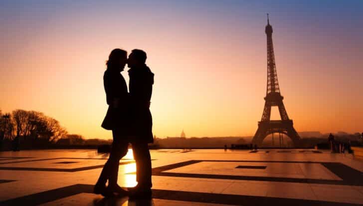 Silhouette of a couple embracing in front of the Eiffel Tower during sunset