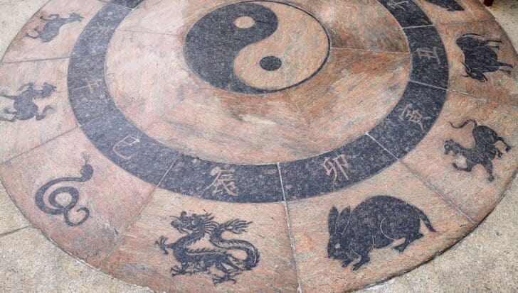 Circular stone with Chinese zodiac symbols and a yin yang symbol in the center