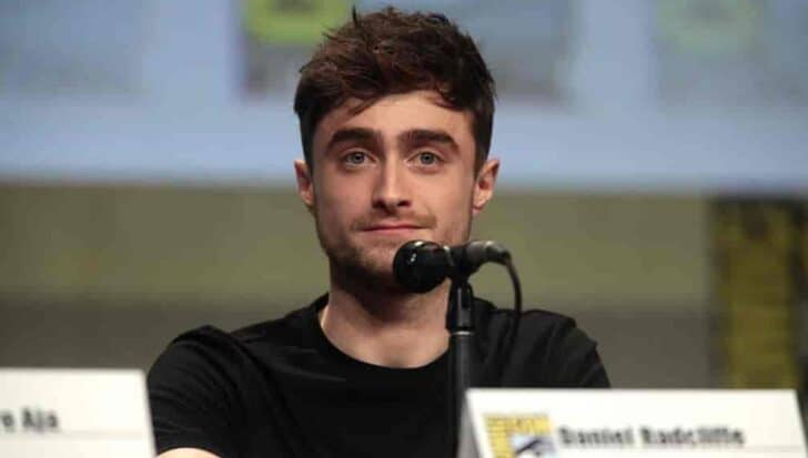 Daniel Radcliffe speaking into a microphone at a panel event