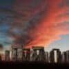 Stonehenge with a dramatic sunset sky and a crescent moon